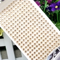 Detail of round acrylic rhinestones with gold borders for DIY crafts and decorations - 6mm / Champagne