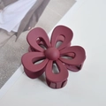 Close-up of a matte burgundy flower hair claw clip on a minimalist white background - Chocolate