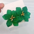 Detailed close-up of green acrylic flower earrings with golden core and matte texture - Verdant