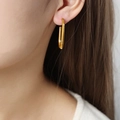 Orecchini geometrici ottagonali placcati in oro 18 carati indossati da una modella - Oro