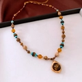 Macro shot of tiger eye stone heart pendant and colorful turquoise beaded necklace - 40# Titanium Steel Glass Round Pendant Necklace