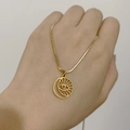 Detail of 18K gold snake chain necklace with hollow sun evil eye pendant on hand - Evil Eye
