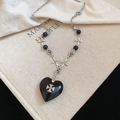 Detail of Gothic black heart pendant with silver cross crest on vintage chain necklace - Shiny Black Heart Cross Style