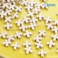 Detailansicht von 13mm cremeweißen Kunststein-Kreuzperlen für DIY-Schmuckherstellung - Blumenkreuz (13mm)