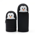Collapsible black penguin silicone pencil case showing both extended and retracted sizes - Penguin Foldable