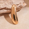 Macro di una spilla a goccia in oro lucido su roccia naturale con riflessi di luce nitidi - Forma a baccello lungo / Oro