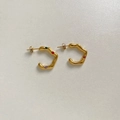 Macro detail of gold C-shaped wavy earrings with colorful gemstones on textured paper - Gold Multicolor Zirconia (DEK1653)