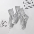 Trois paires de chaussettes grises tricotées avec bords-côtes sur surface blanche - Nervuré Gris