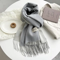 Detailed view of gray cashmere-like scarf texture with stylish fringe and woven label - Light Gray