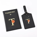 Detail of black passport holder and luggage tag set with golden letter T and balloon - Black Letter T