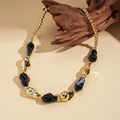Detail of bohemian acrylic chunky necklace with gold and black marble beads on driftwood - Black