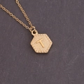 Detailed close-up of a golden hexagonal pendant necklace featuring a raised letter T design - Letter T (20#T)