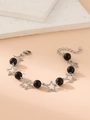 Detail of star-shaped silver links and black beads on a sun moon charm bracelet - Black Bead Star
