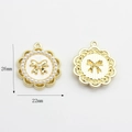 Detailed view of round gold frame charm with bow, pearls, and 26mm x 22mm dimensions - White