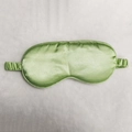 Green silk satin sleep mask with elastic strap shown on a white textured background - Mint Green