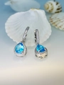 Detailed close-up of pear-shaped blue crystal lever-back earrings with silver pavé frame - Lake Blue