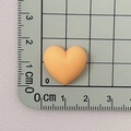Macro view of a matte peach heart resin accessory on a grid ruler showing 2cm scale - Orange