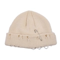 Detail of distressed beige beanie with safety pin and silver metal rings trim - One Size / Beige