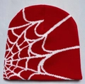 Detail of red knit beanie featuring a white spider web jacquard pattern and tight texture - Red with White Web