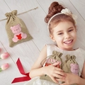 Detail of child holding small burlap gift bags with pink bear design and XOXO text - 10*14cm / Bear Style