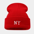 Gros plan du bonnet en tricot rouge montrant la broderie blanche NY détaillée - Rouge