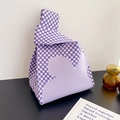 Purple and white checkerboard knit tote bag with heart patterns on a desk - Purple