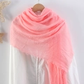 Detailed close-up of pink crinkle cotton scarf with fringe edges on wooden hanger - Pink