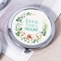Silver metal compact mirror with floral wreath and 'Love IS ALL AROUND' quote design - Love Is All Around