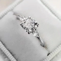 Driesteens ring met kussengeslepen zirkonia en zijstenen in een fluwelen doosje - US 5 / Witgoud