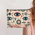 Hand holding canvas pouch featuring bohemian evil eye pattern and secure zip closure - Off-White Blue Pink Evil Eye (jiayingpbb0427)