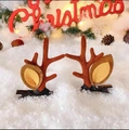 Close-up of brown plush reindeer antler hair clips on white snow with festive Christmas decor - Brown Antlers with Leaves Pair