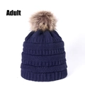 Detail of dark blue cable knit beanie for adults with a large brown faux fur pom pom - Navy Blue