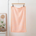 Absorbent orange and white checkered cotton tea towel with waffle texture on wooden hanger - Orange