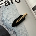 Detailed close-up of a minimalist black acetate hair clip with a polished gold metal clasp - No-Crease Hair Clips / Black
