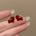 Detailed macro view of 18k gold plated unicorn stud earrings with red enamel - Red Gold Winged Horse Style (Silver Pin)