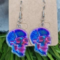 Makroaufnahme der holografischen Totenkopf Ohrringe aus Acryl mit blau-violetten Reflexen - Blau-Lila Holografischer Totenkopf