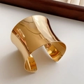 Polished gold cuff bracelet detail with mirror finish on white surface and jewelry box - Gold Mirror Minimalist Wide Cuff Style