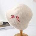 Close-up of cream fleece bucket hat featuring red bow decoration and button detail - Beige