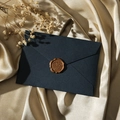 Enveloppe en lin bleu marine avec sceau de cire marron sur tissu en soie champagne - Bleu