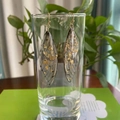 Detail of elegant S925 silver cicada wing earrings with gold foil in resin on a glass rim - Grey Gold Foil