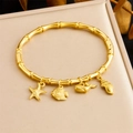 Bracciale rigido dorato in acciaio con ciondoli marini, stella marina e conchiglia - Serie Oceano Stella Marina Pesce Balena Conchiglia (B1627)