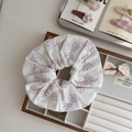 Detailed view of a white floral cotton scrunchie with purple patterns on a wooden tray - Light Purple Polka Dot Bow