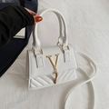 Elegant white quilted crossbody bag with golden V-shaped hardware and tassel detail - White