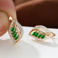 Close-up of champagne gold leaf earrings with emerald zircon and small white diamonds - Champagne Gold Emerald