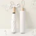 Off-white foldable sun umbrella with matching storage case and elegant bow decoration - Off White