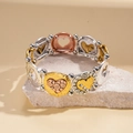 Detailed macro view of mixed metal bracelet with heart charms on natural stone - Tri-color Heart Patchwork Style