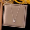 Macro detail of silver teardrop pendant necklace resting on a beige jewelry box - Water Drop / Steel