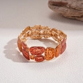 Detail von bernsteinfarbenem Harz und gehämmertem Goldmetall am Boho-Stretch-Armband - Goldene Basis Rot (Armband-Rot)
