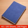Blue A5 matte soft leather notebook with 100 sheets on a wood grain background - 200 Pages / A5-Blue