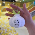 Cute plush garlic keychain with crying expression and green leaves on yellow background - Garlic + Ball Chain